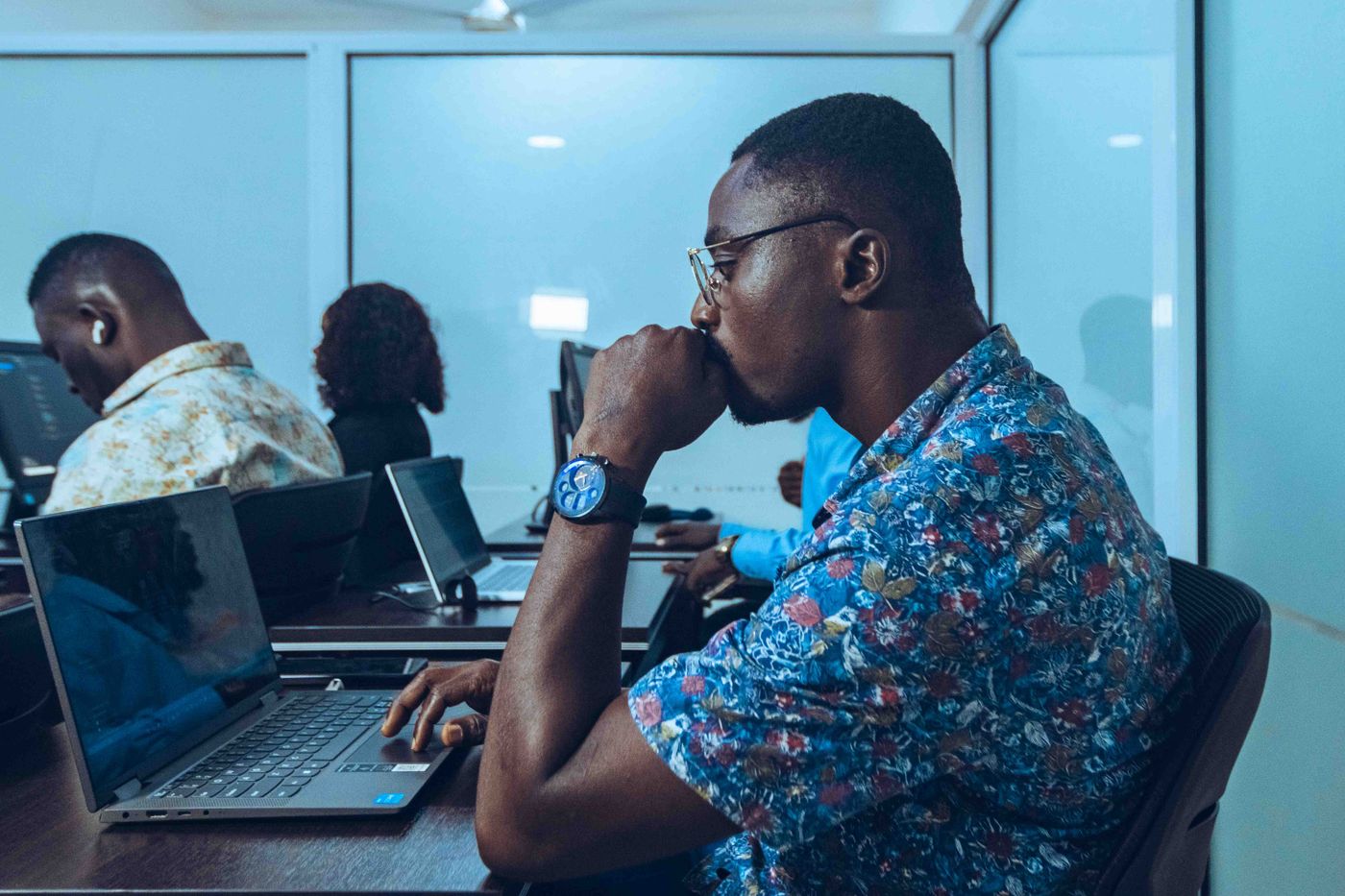 A person working at a laptop in a computer lab